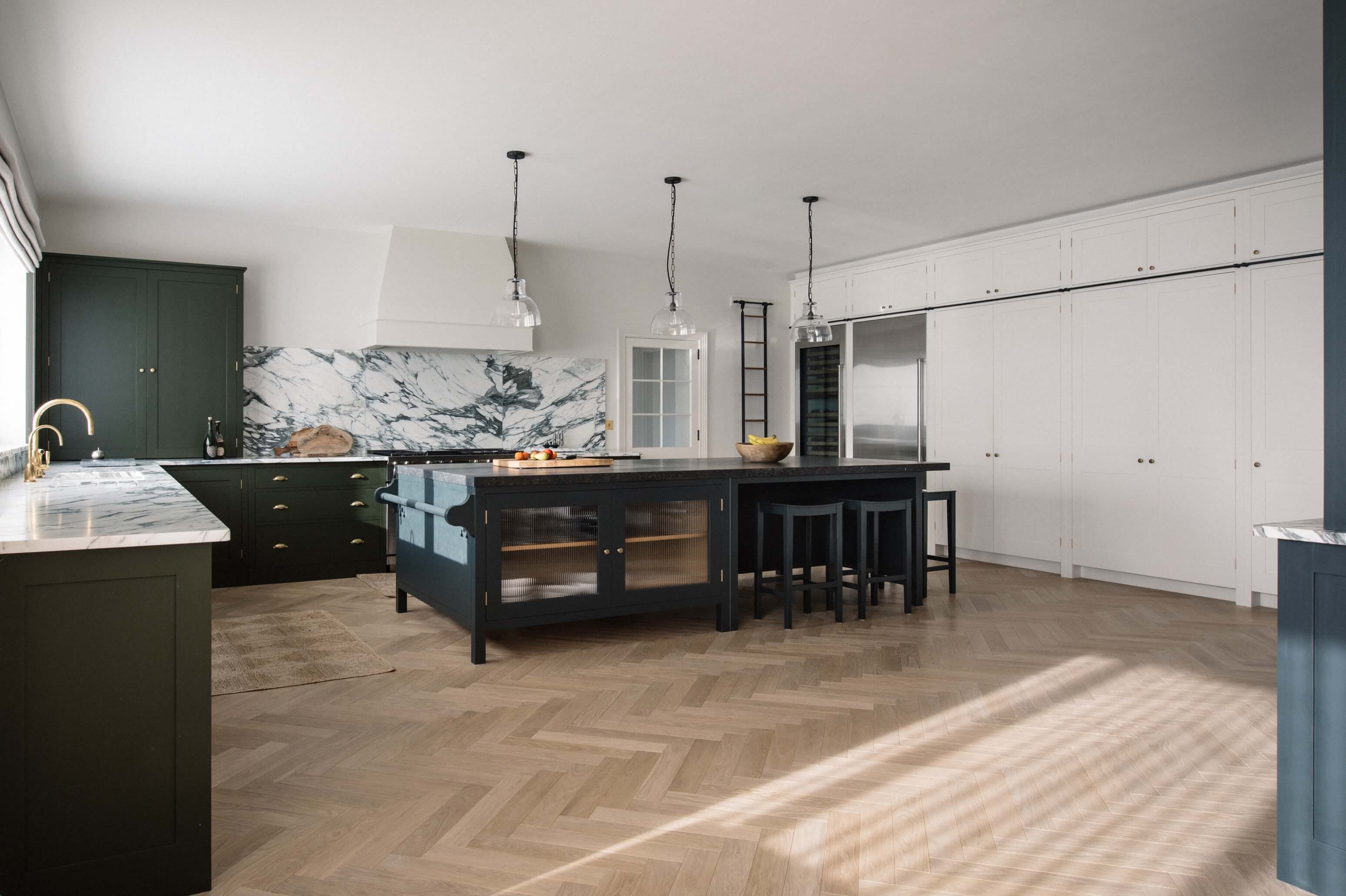  Traditional kitchen design with dark green cabinets, marble backsplash, and wood floors