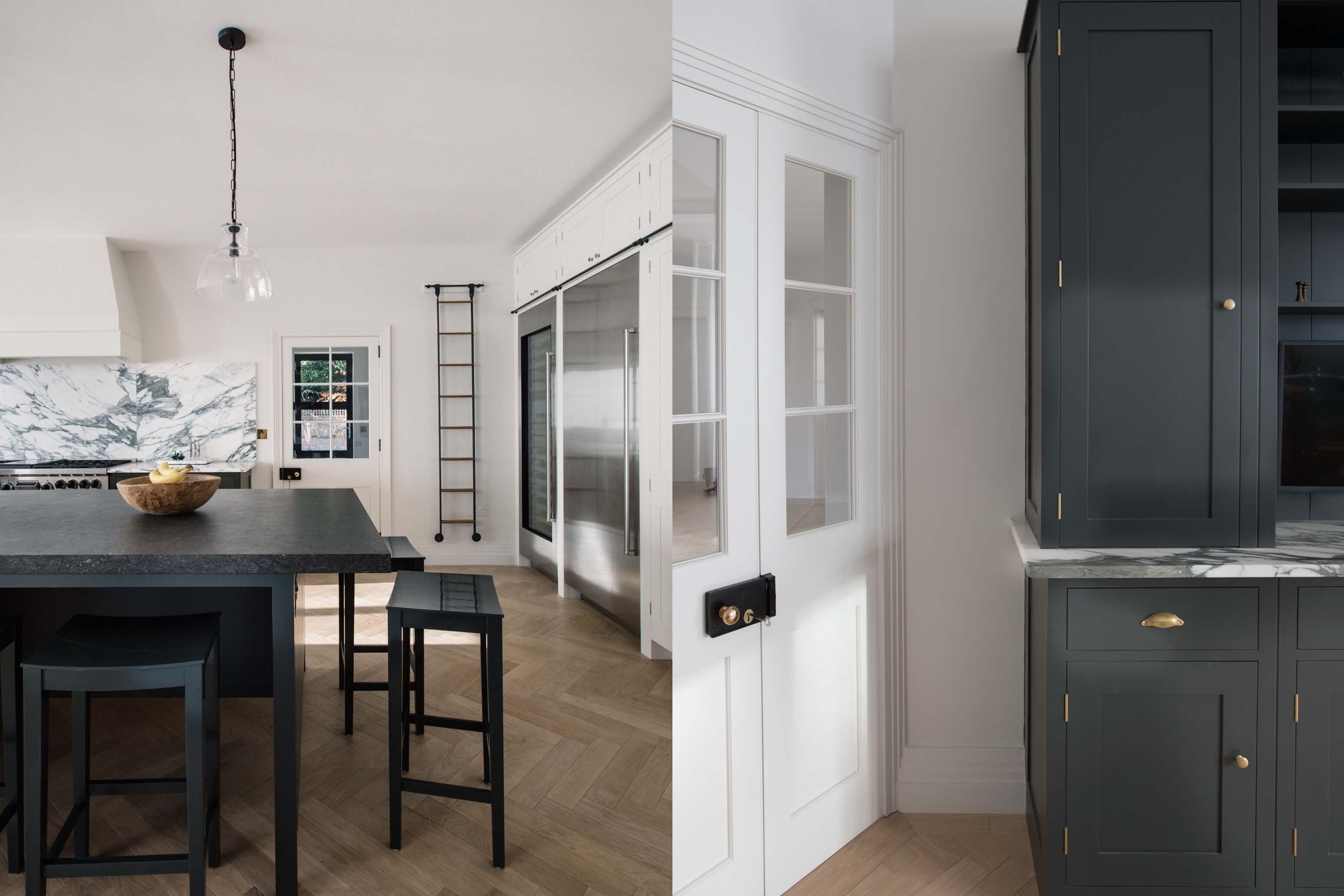  Light black kitchen island, hanging ladder, stainless steel fridge, and white cupboard designed by Plain English