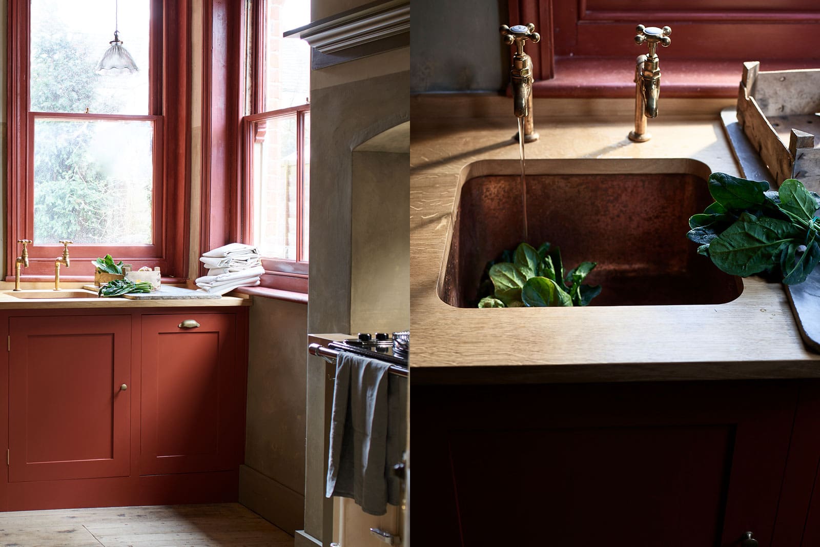  Rustic kitchen with red cabinets, a copper sink, brass taps, and fresh greens on the counter under tall windows.