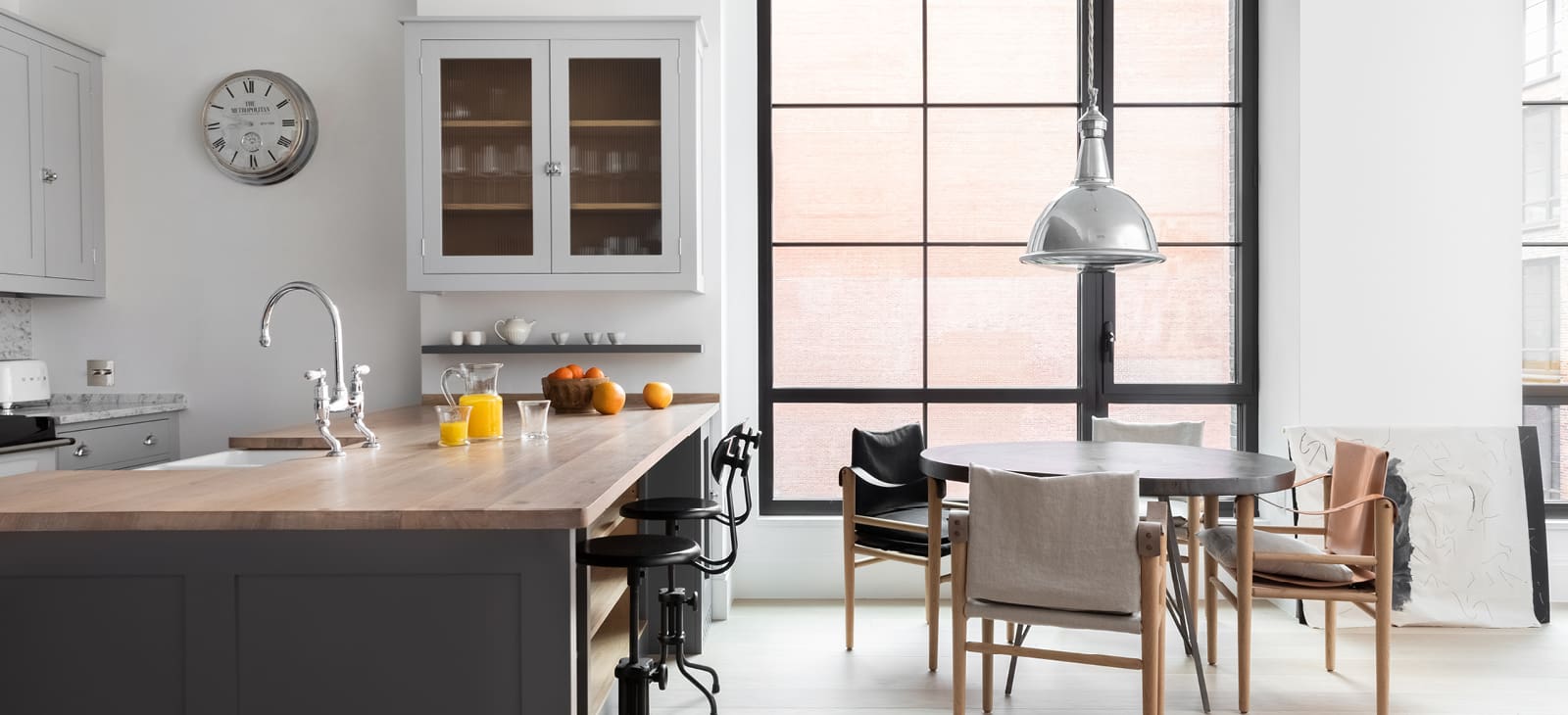  Townhouse kitchen with wood kitchen island, light gray cabinets, and small table