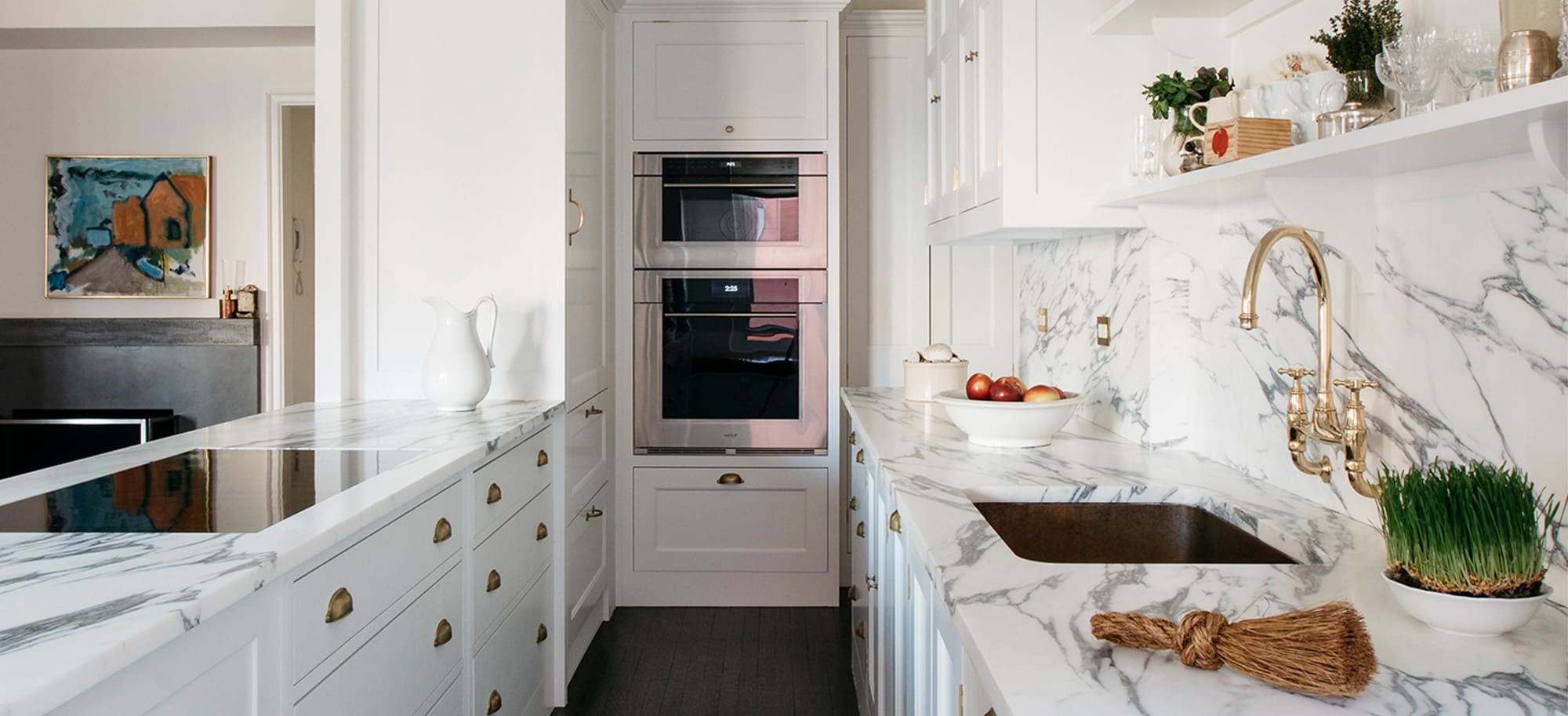  Apartment kitchen with Spitalfield cabinets, Folgate doors, marbile countertops, brass fixtures, and warm dark wooden flooring.