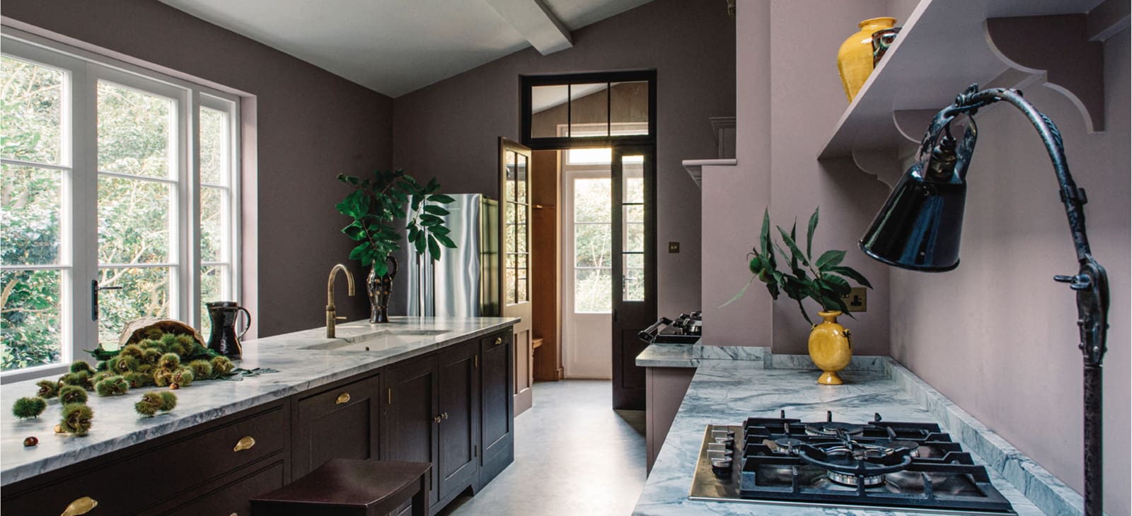  North Hill kitchen interior with a custom cabinetry design in dark wood, a large kitchen island, and modern lighting fixtures, showcasing the bespoke craftsmanship of Plain English.