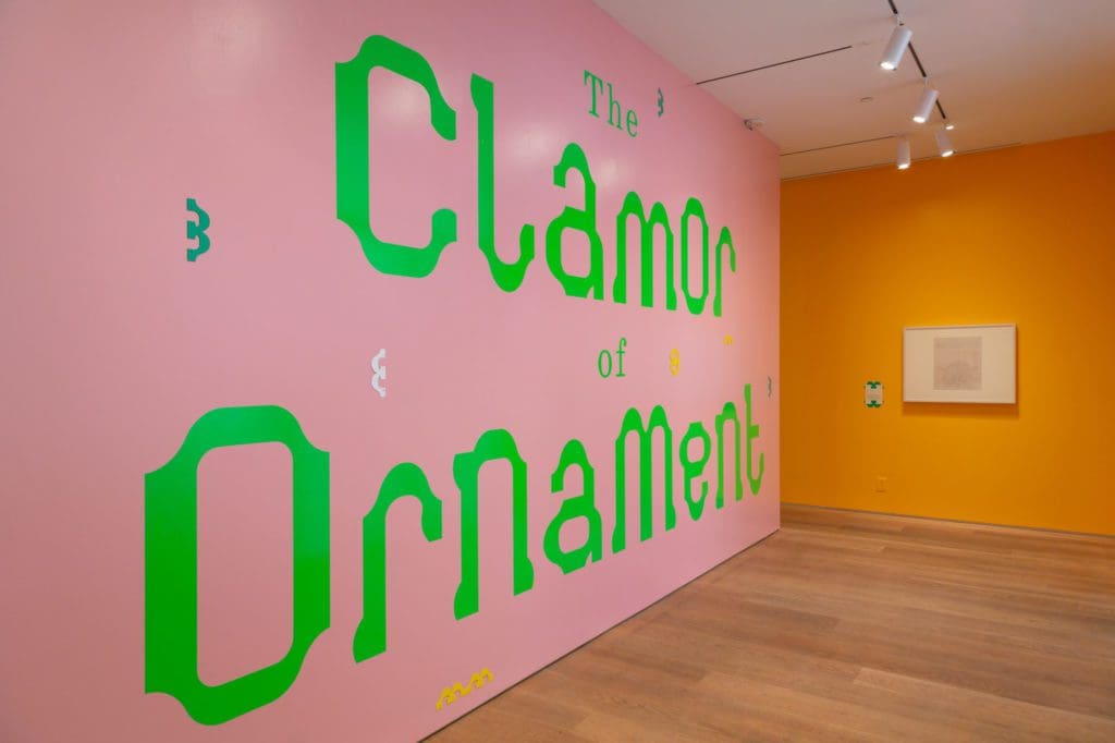 Pink wall featuring, in green paint, 