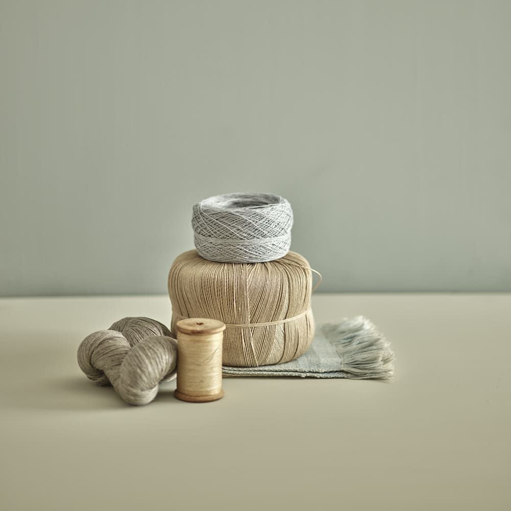 Close up of beige and grey spools of thread.