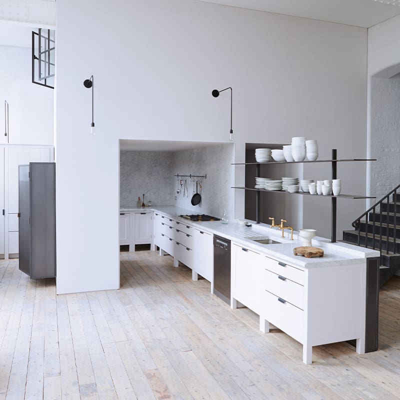 All white kitchen design featuring custom cabinets and open shelving.