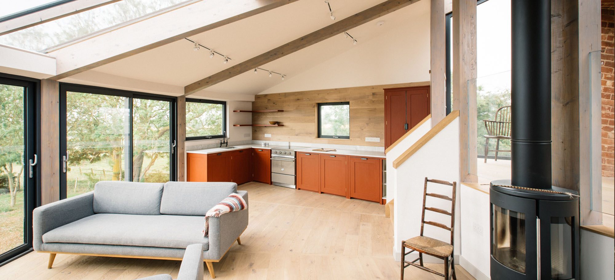 Custom pool house design with large windows and custom orange cabinets. 