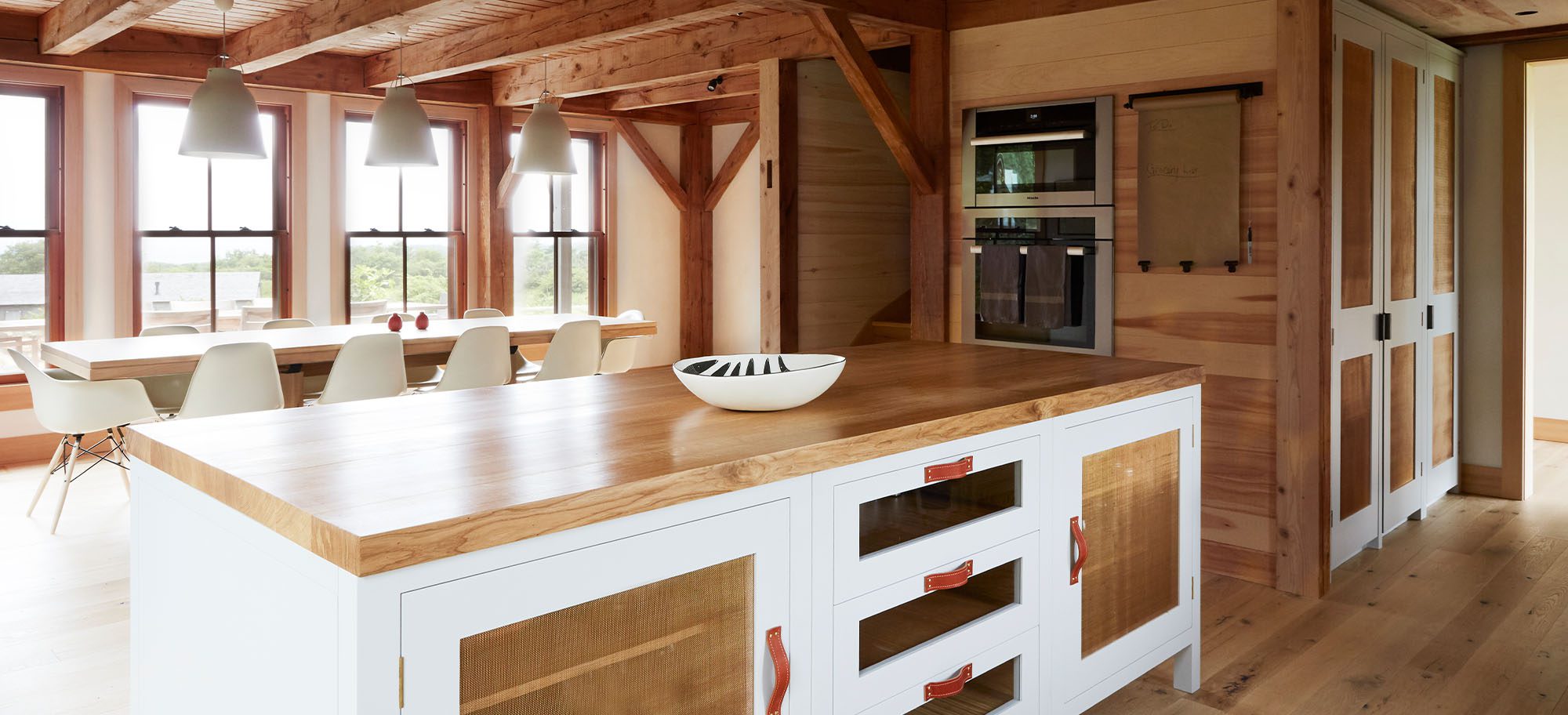 Bespoke pool house featuring wood accents throughout and custom white cabinetry. 