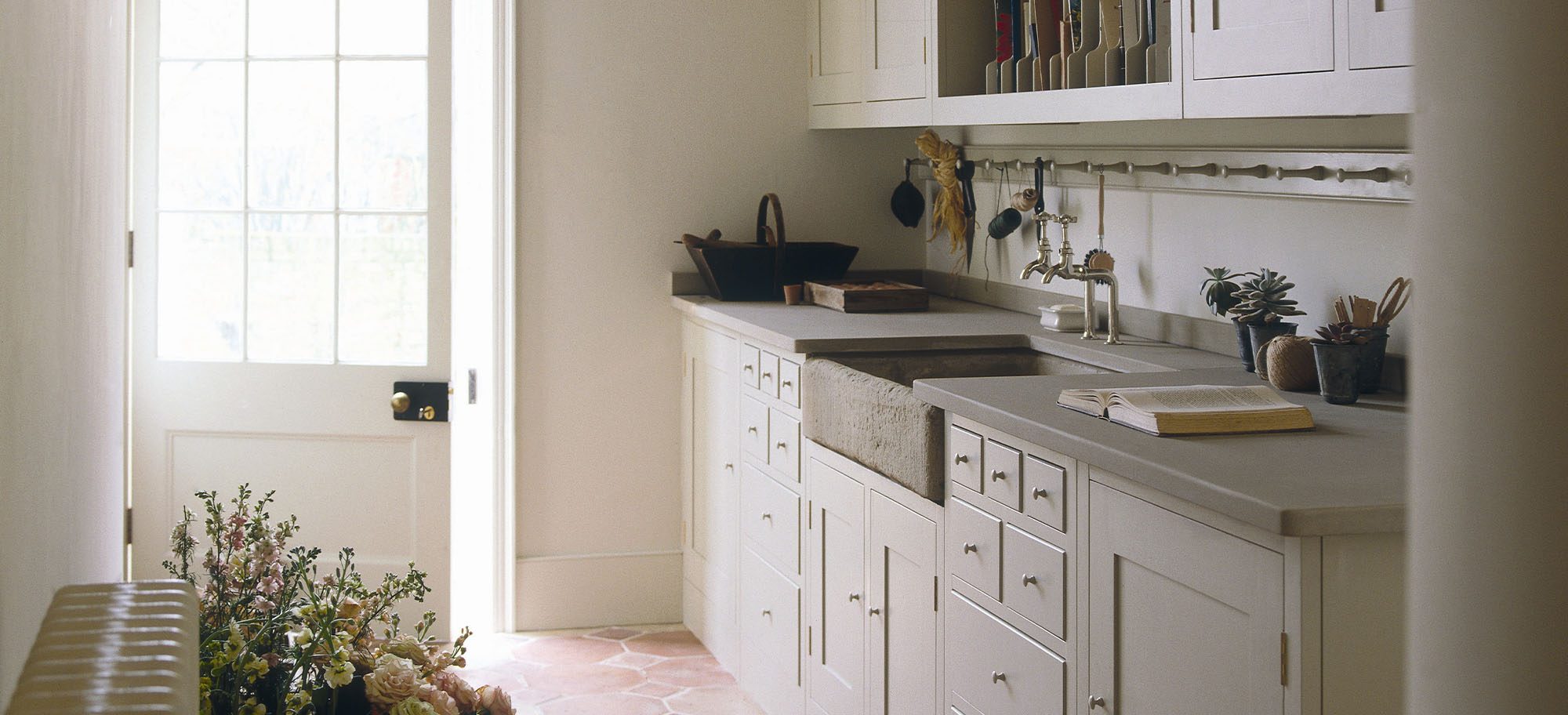 Custom designed scullery with grey countertops and white cabinets and walls. 