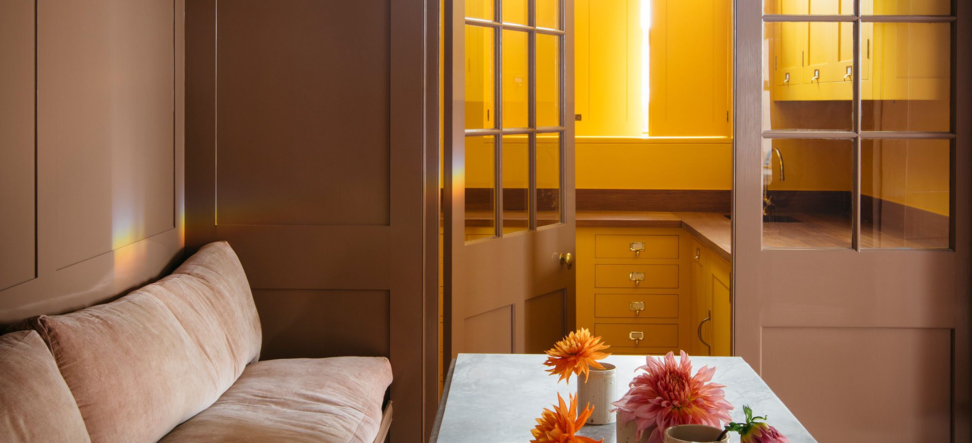 Brightly lit scullery with custom cabinets and windowed doors. 