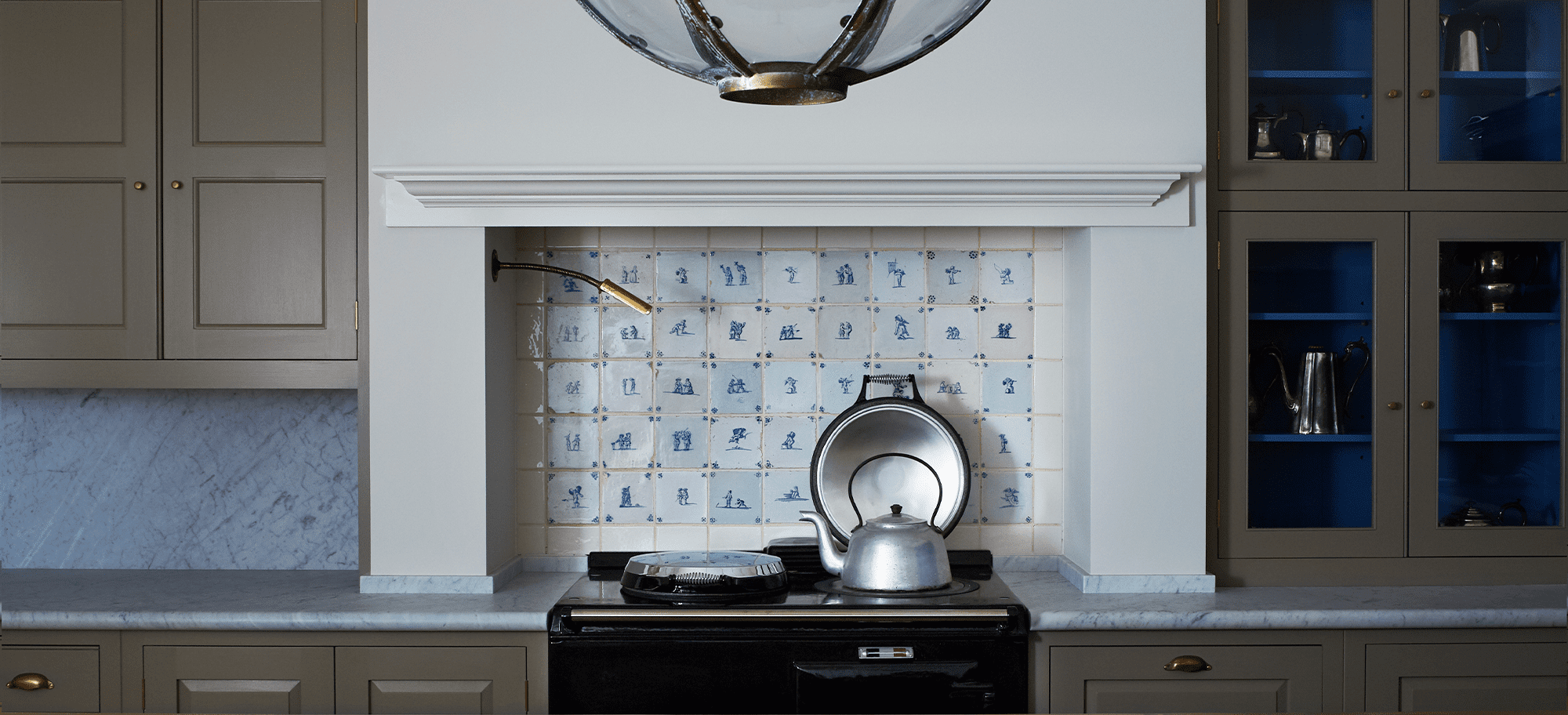  Custom bespoke kitchen design with brown cabinets and a delft tile backsplash.