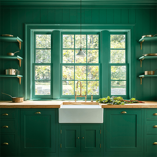 Custom bespoke kitchen with bright green walls and cabinets.