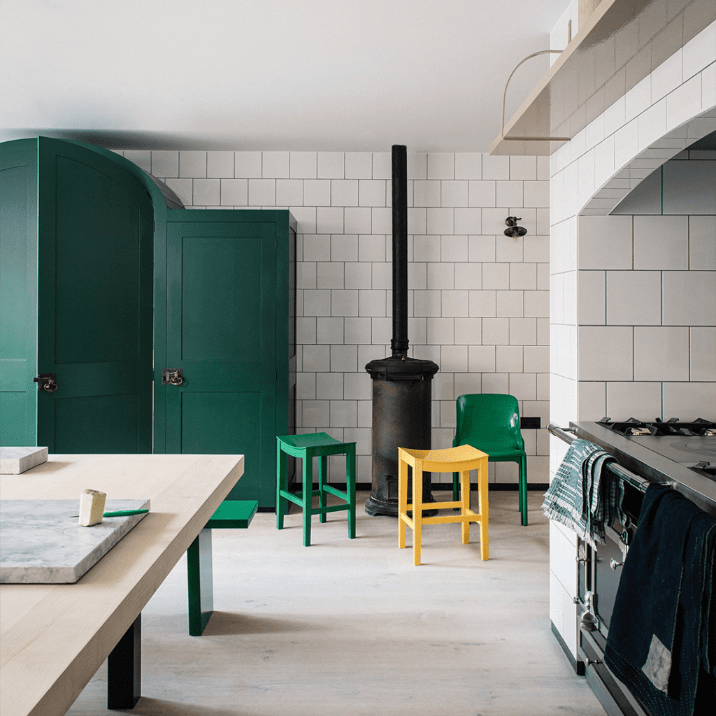 Custom cabinetry in deep green with custom stools in green and yellow.