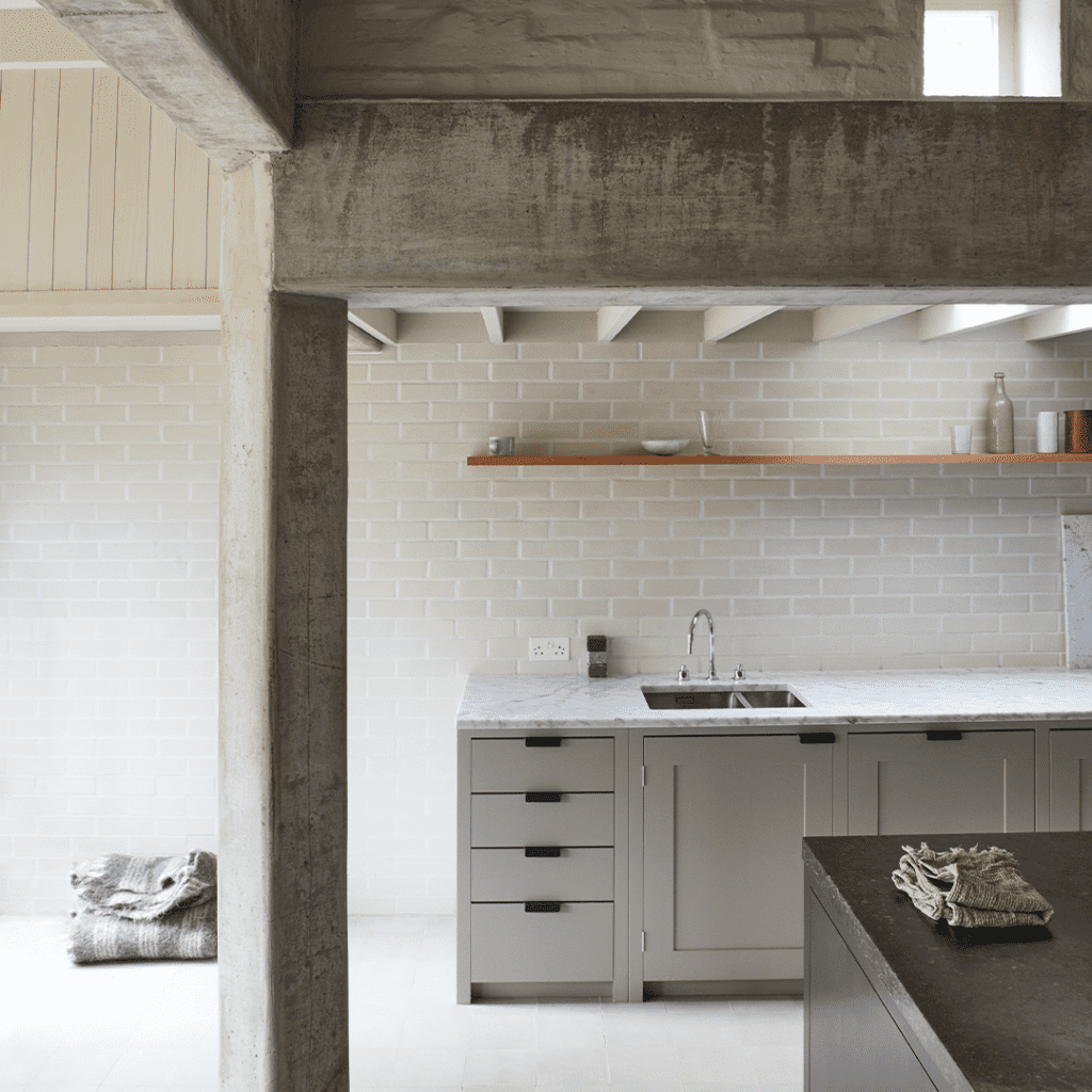 Bespoke cabinetry in soft gray with marble countertop and minimalist shelving.