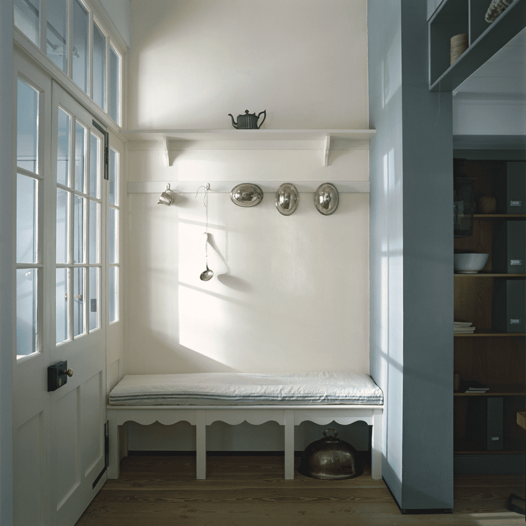 Bespoke cabinetry with white bench, scalloped edge, and wall-mounted silver utensils.