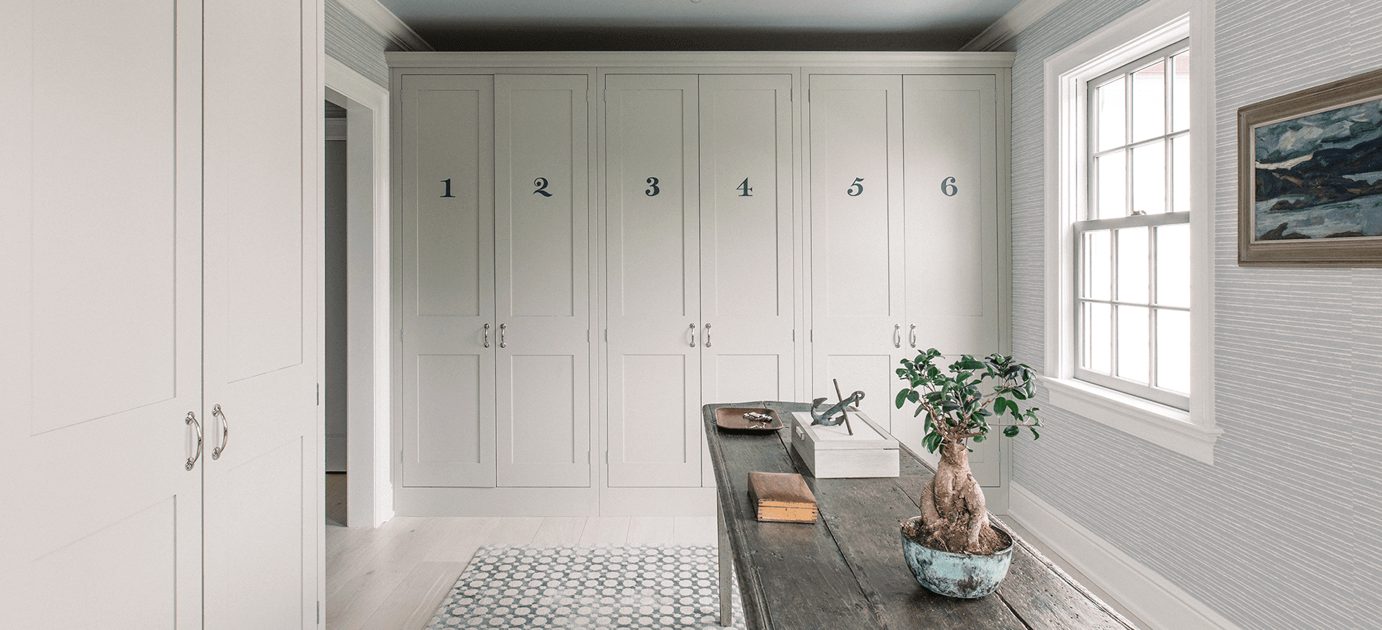  Plain English cabinets in soft white, featuring numbered doors. Custom design with elegant handles.