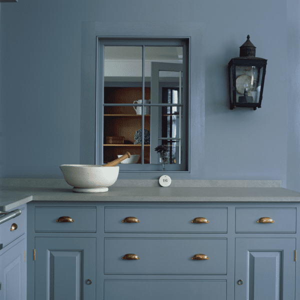Custom blue cabinetry with brass handles, featuring a custom countertop.