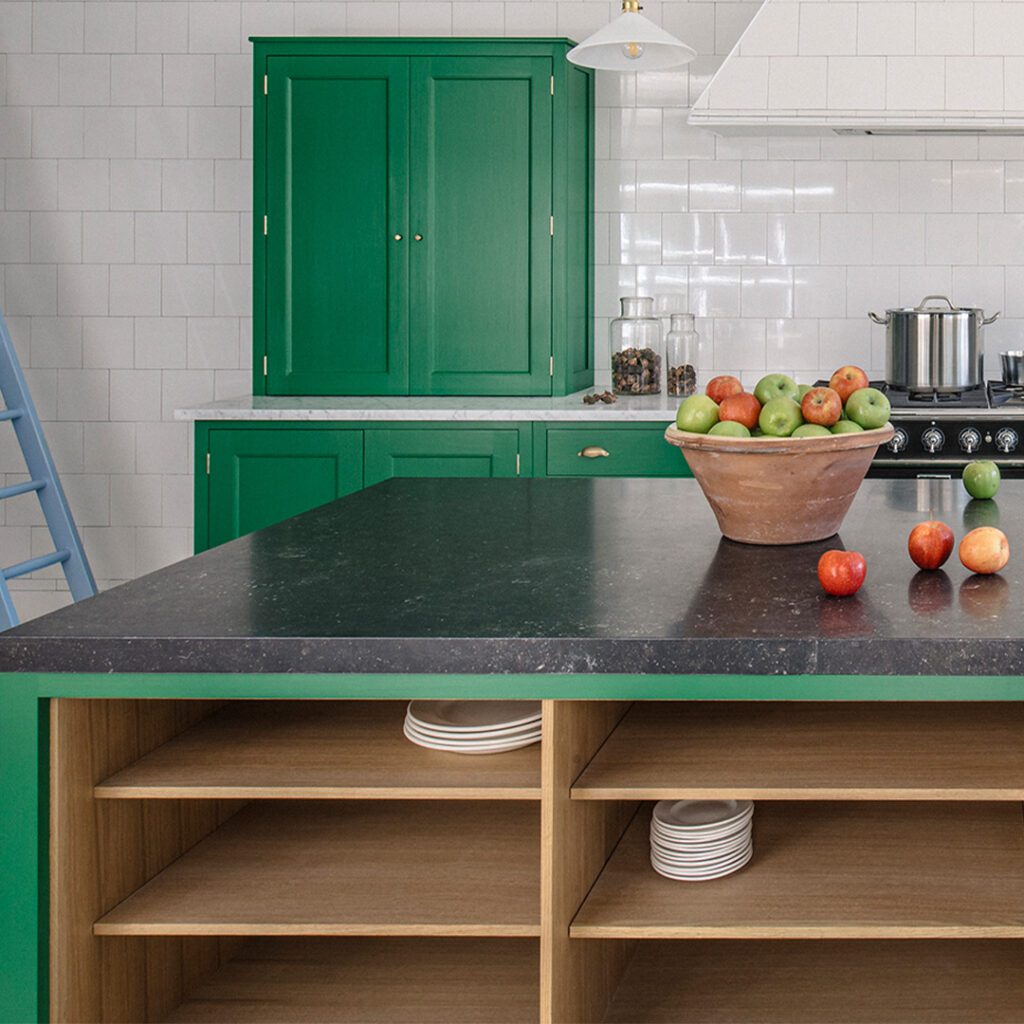 Bespoke green cabinetry with black countertop and open shelving.