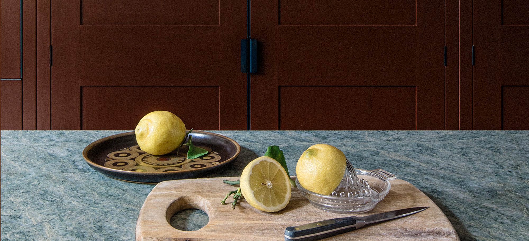  Close up of lemons on a countertop, with custom Plain English cabinets in the background.