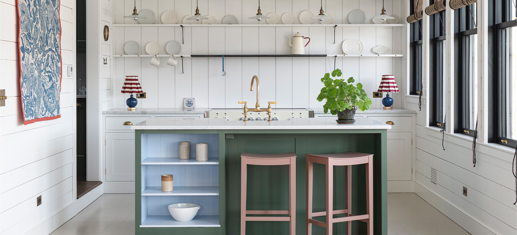  a lakeside cottage kitchen with open shelving, white shiplab walls, a green kitchen island, and white marble countertops