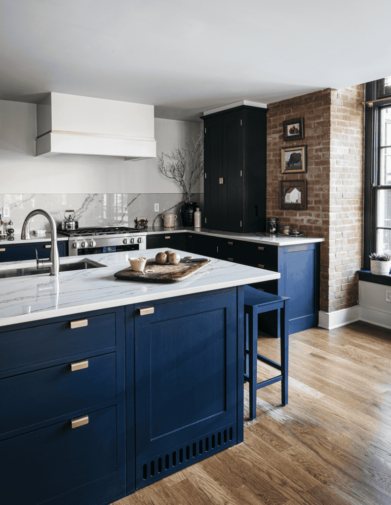 a kitchen featuring navy blue shaker-style cabinetry with gold hardware and a marble countertop island with built-in seating