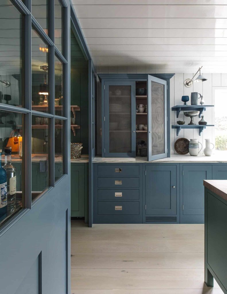 a custom kitchen painted in a muted blue color, open shelving and closed cupboards