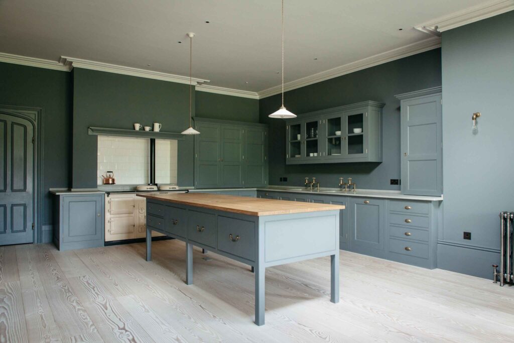 Open kitchen space with walls, cupboards, and cabinets painted in stone color and wood island countertop