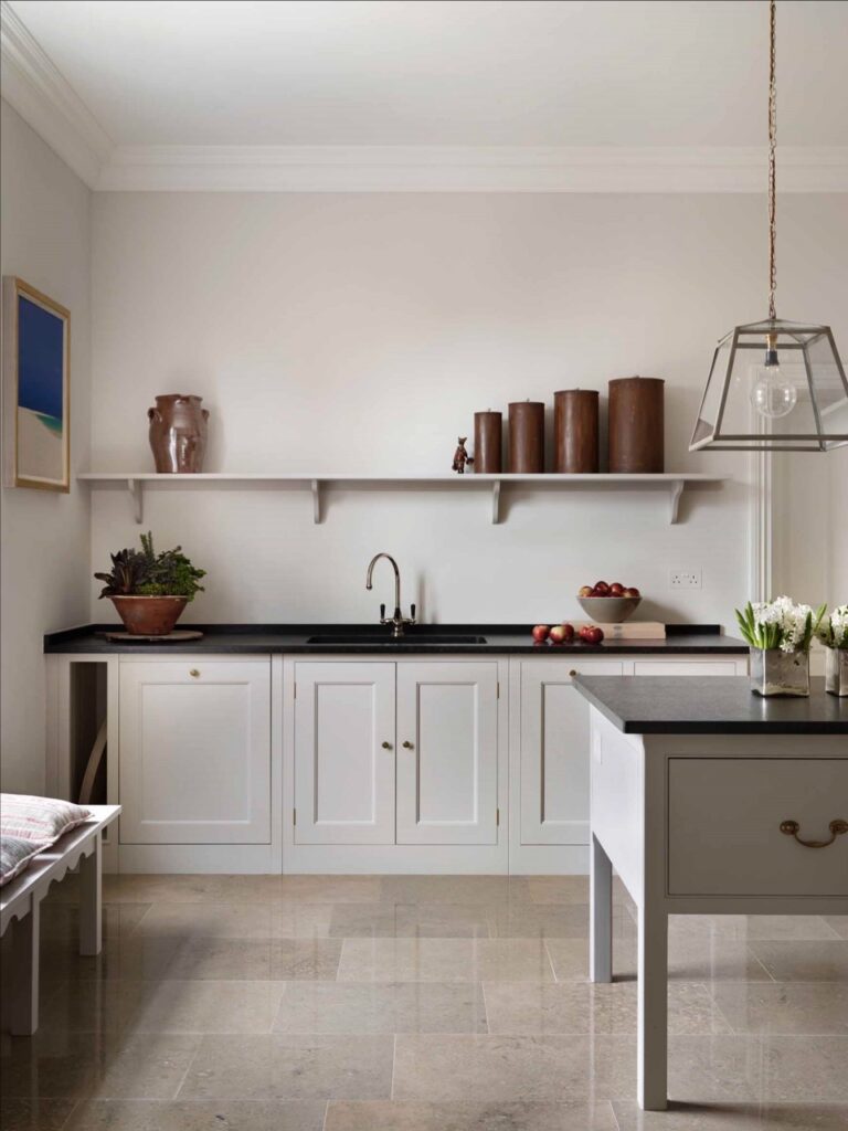 a classic English kitchen featuring white cupboards and open shelving