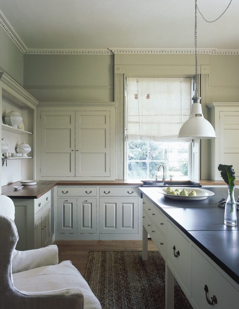 a kitchen with an elegant, traditional-style cabinets with classic paneling and dark topped counters