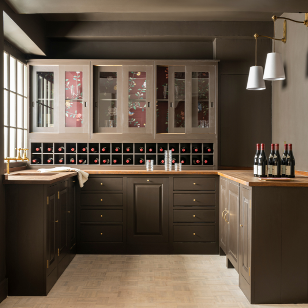 Dark cabinetry wet bar with wood countertops, glass-front cabinets, and built-in wine storage.